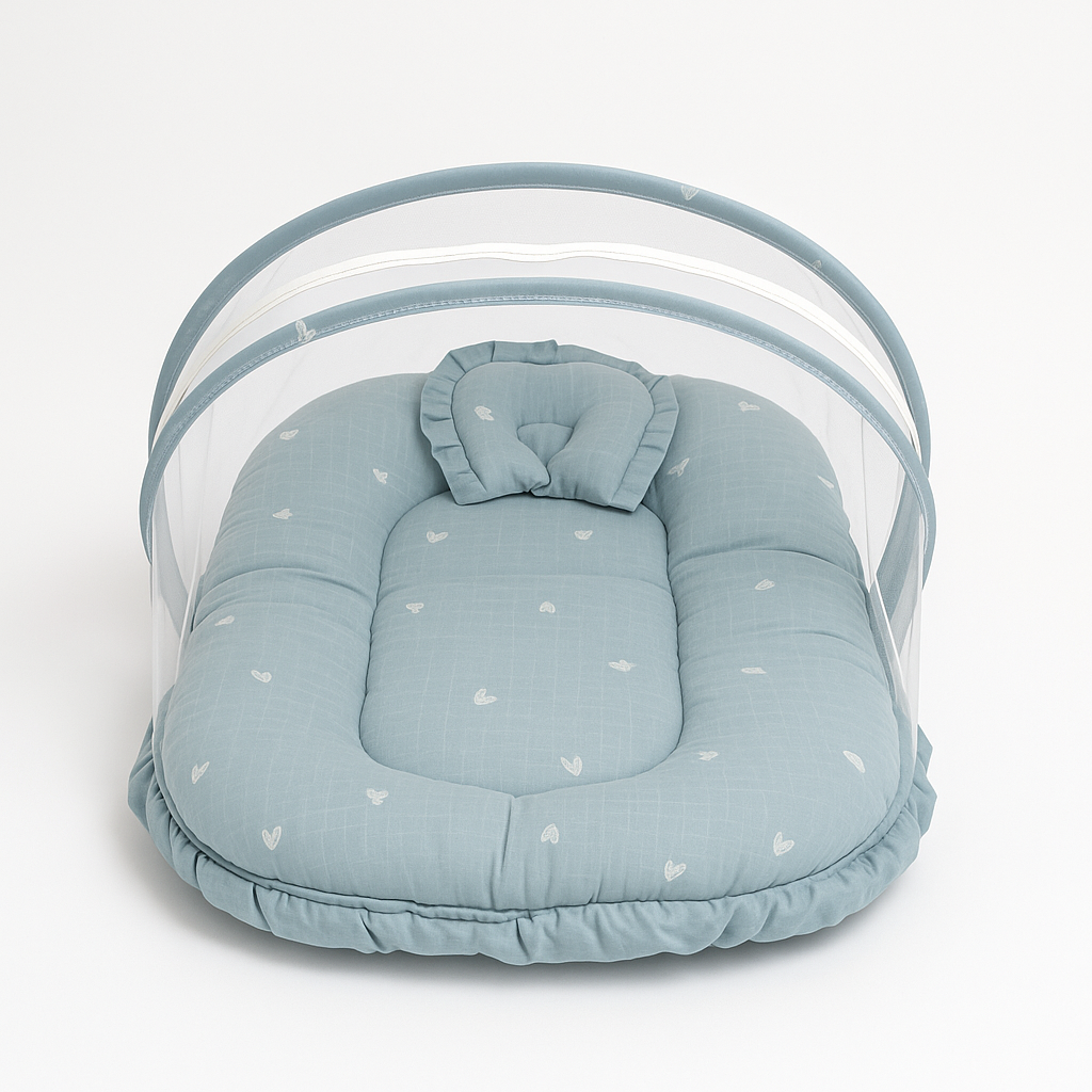 Blue baby bed with white heart print, pillow, and protective mosquito net canopy
